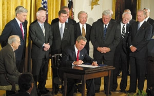 As supporters look on, Bush signs the Bill Of Rights Reduction And Consolidation Act.